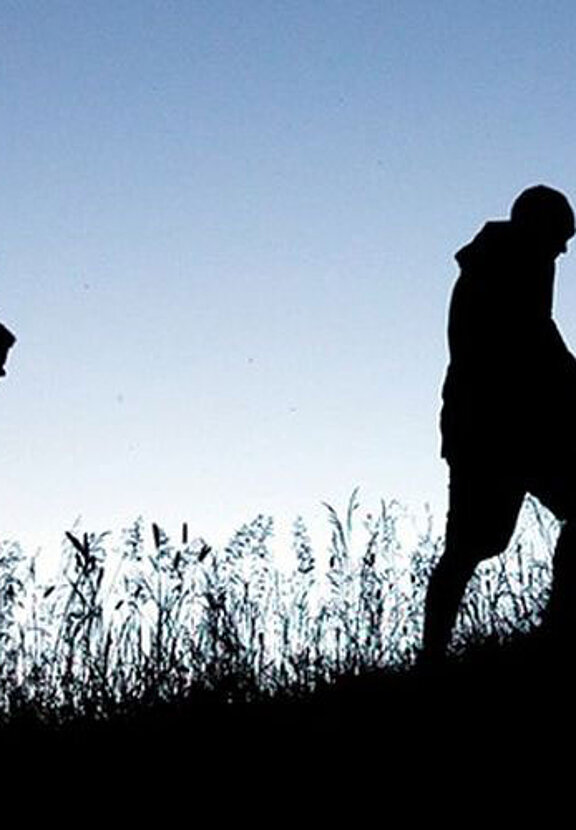 Several people are walking up an ascending path.