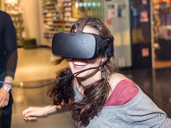 A woman wears black simulation glasses and laughs