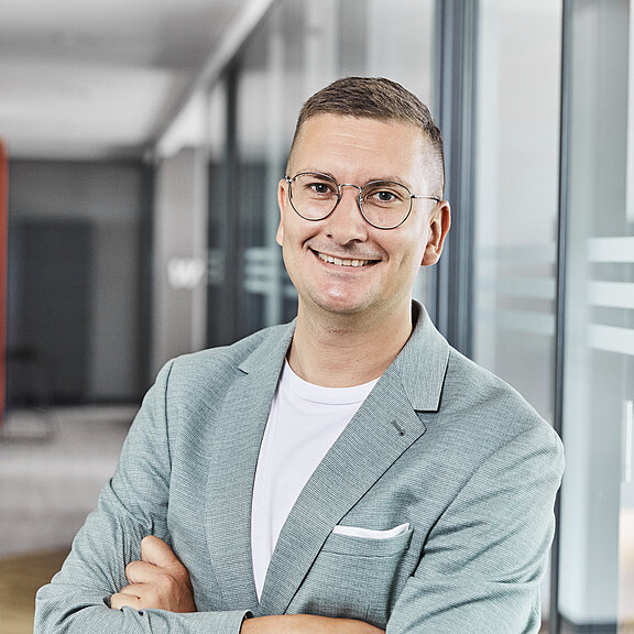 Portrait von Kevin Kurz, der freundlich in die Kamera lächelt.