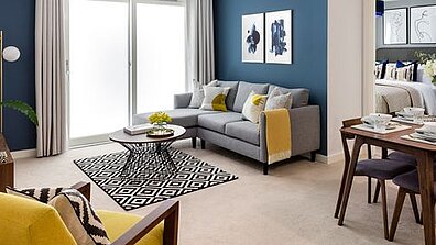 A cosily furnished room with a residential and dining area.