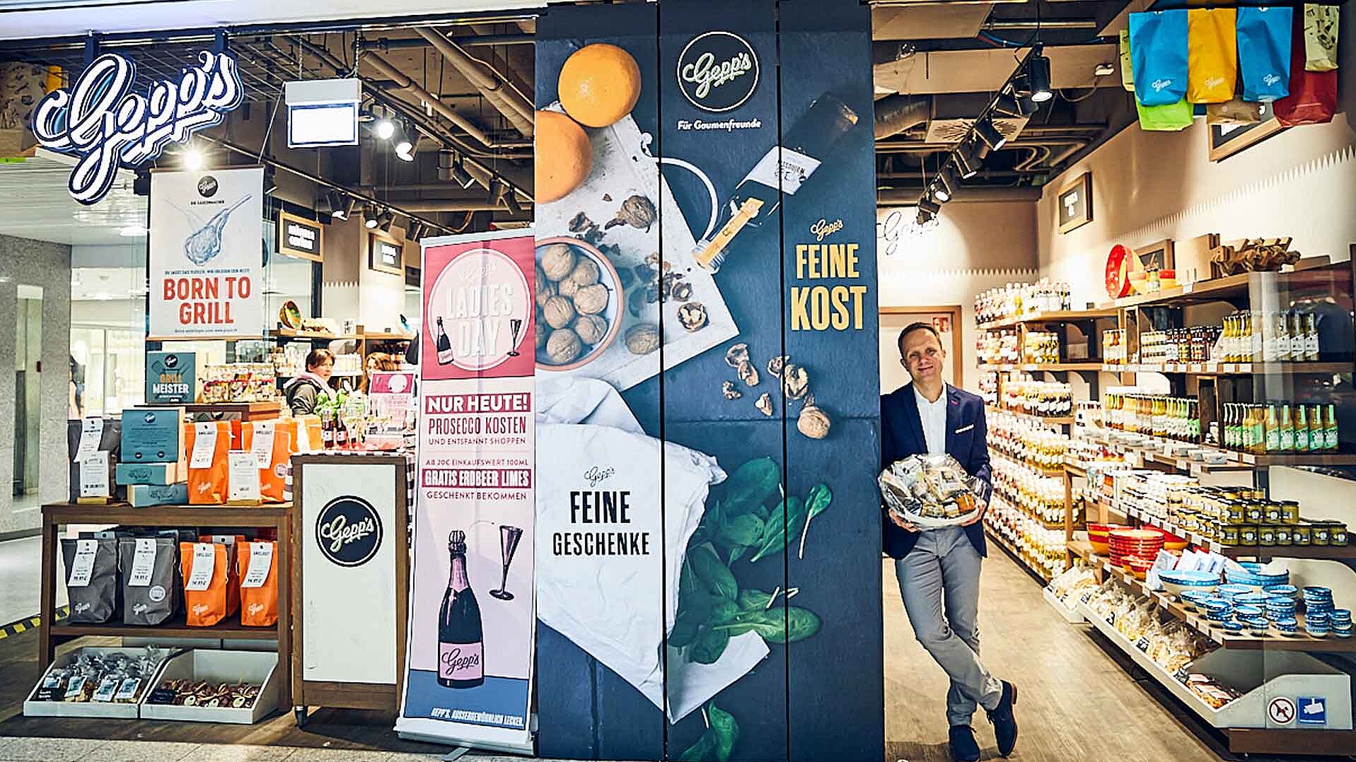 Dr. Alexander Gepp stands in front of his delicatessen &quot;Gepp&#039;s&quot; and holds a gift basket in his hands