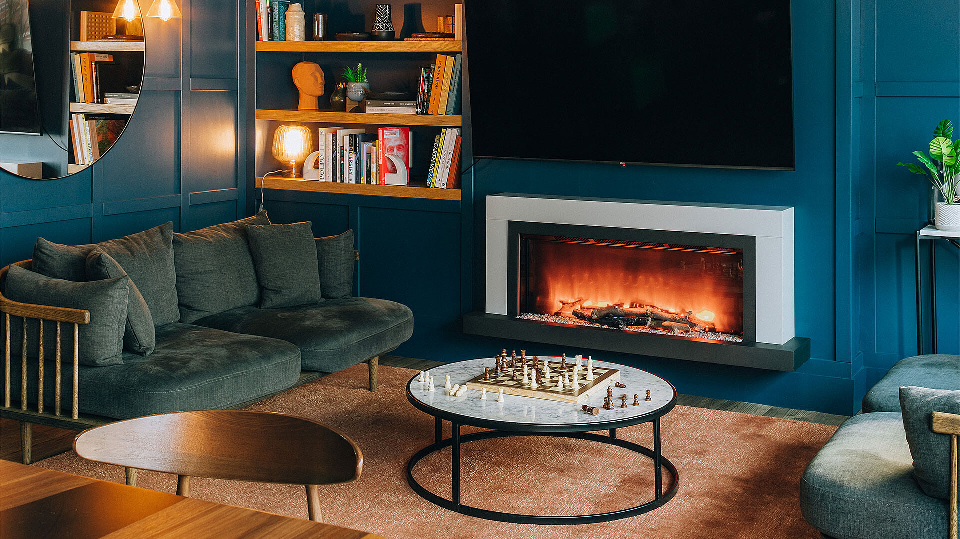 View of a living room with blue walls, a fireplace and various decorations.