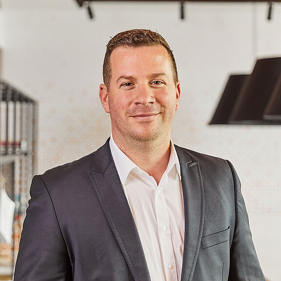 Portrait of Adam Cseresnyesi, smiling friendly into the camera.