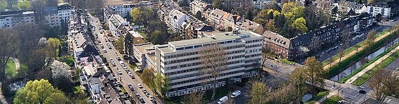 Ein ehemaliges Bürogebäude in Düsseldorf, umgeben von Wohnanlagen und viel Grün.