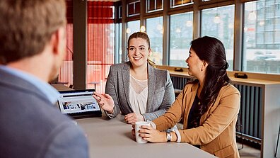 A man and two women are entertaining themselves in an office space