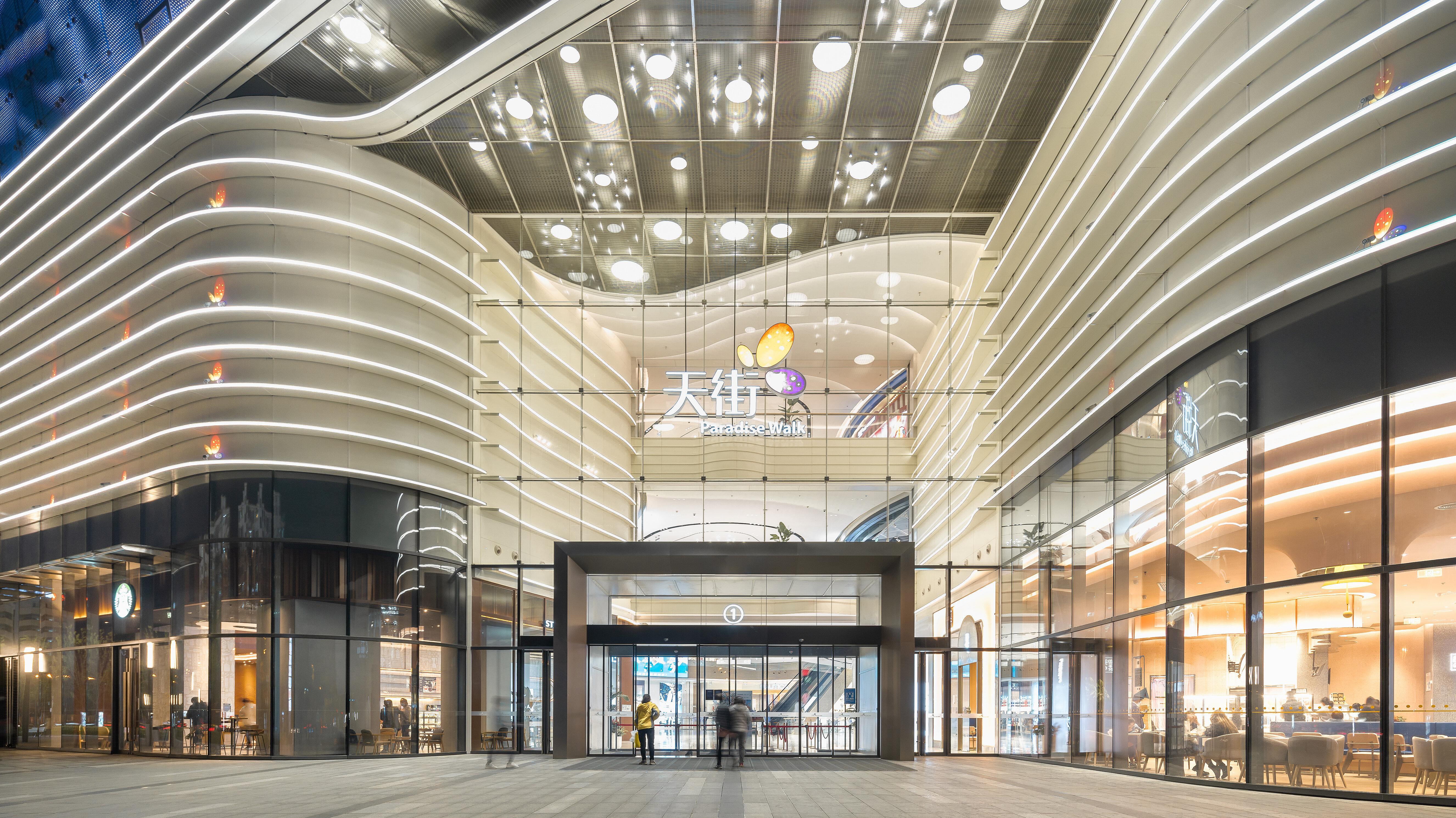 Ansicht des Eingangs eines Shopping-Centers mit geschwungener Architektur.