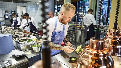 A cook prepares a dish