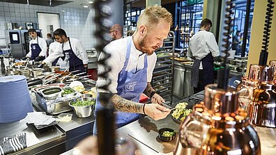 Ein Koch bereitet ein Gericht zu