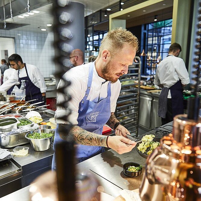 A cook prepares a dish