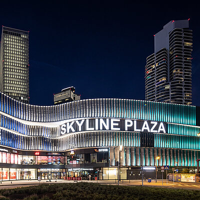 Blick auf ein Einkaufszentrum am Abend mit besonderer Architektur.