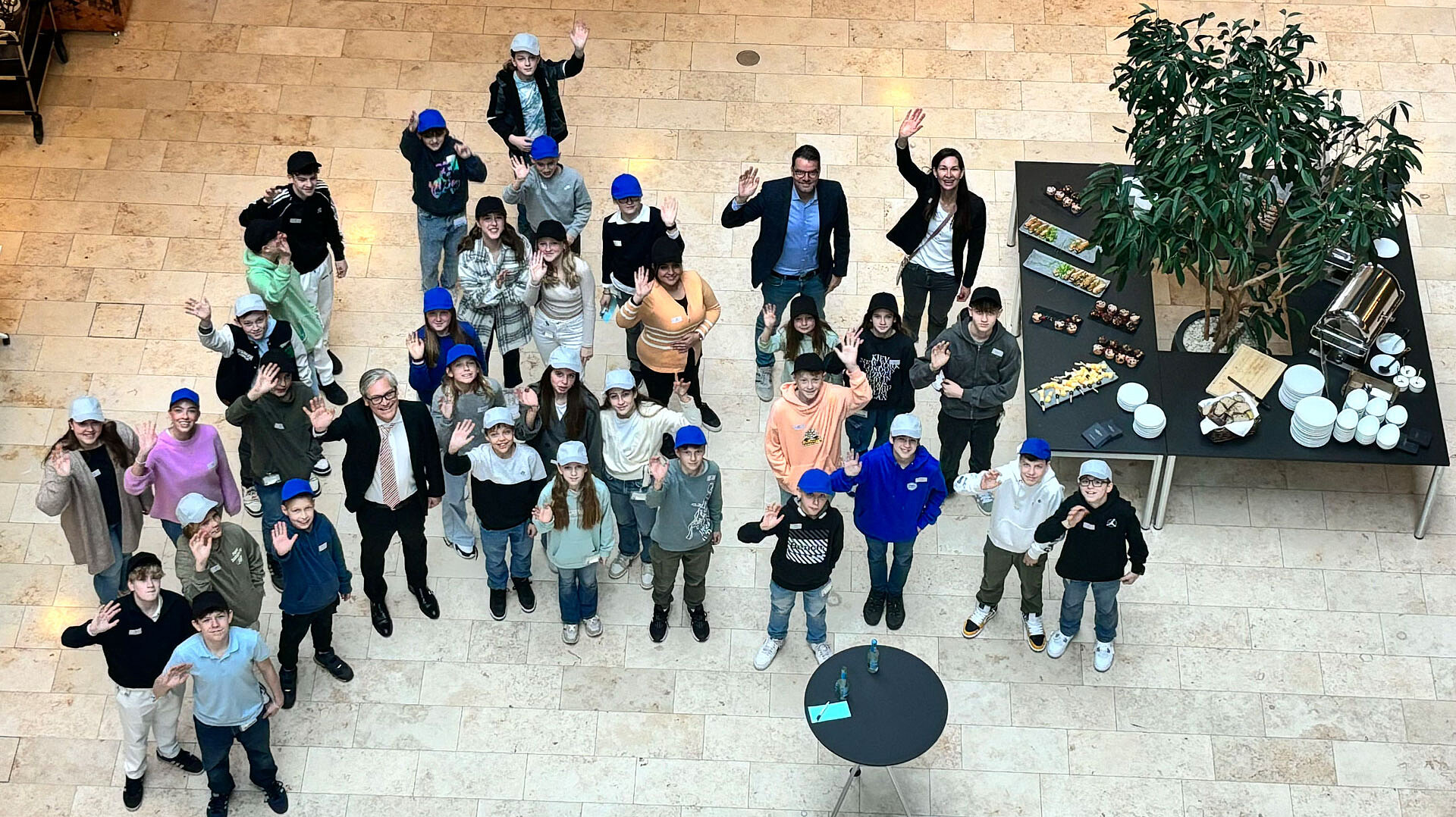 CEO Alexander Otto, some ECE employees and many children stand together and wave at the camera