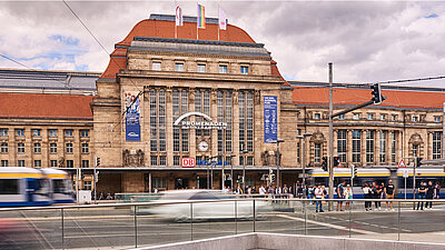 Eine Straßenbahn, die an einem Bahnhof vorbeifährt.