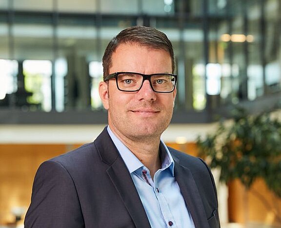 Porträt von Lukas Nemela, der freundlich in die Kamera schaut.