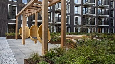 View of a terrace with attached outdoor hanging chairs and green plants.