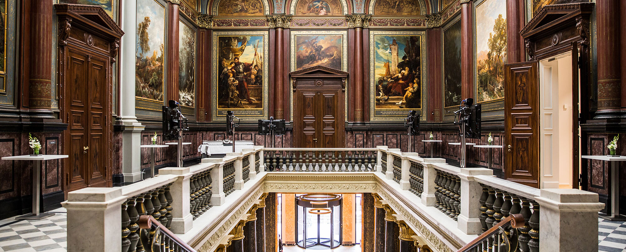 View of the interior of the Hamburger Kunsthalle with impressive paintings and a marble staircase.