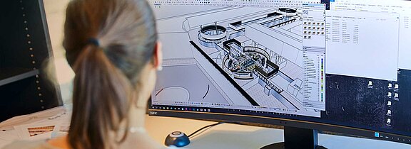 Eine Person arbeitet an einem Bauplan auf einem großen Bildschirm