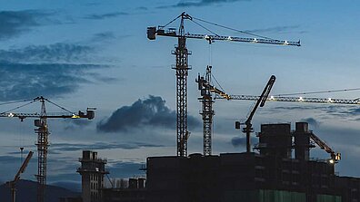 Construction cranes at dusk