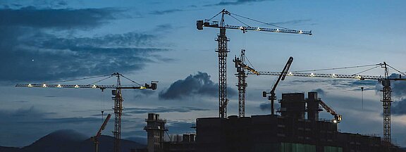 Construction cranes at dusk