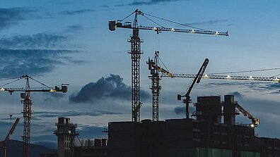 Construction cranes at dusk