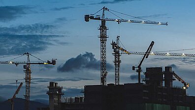 Construction cranes at dusk