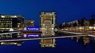 Brightly lit ThyssenKrupp buildings and company logos 
