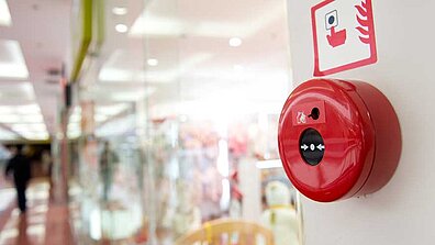 Roter Feueralarm, der sich an einer Wand in einem Shopping-Center befindet