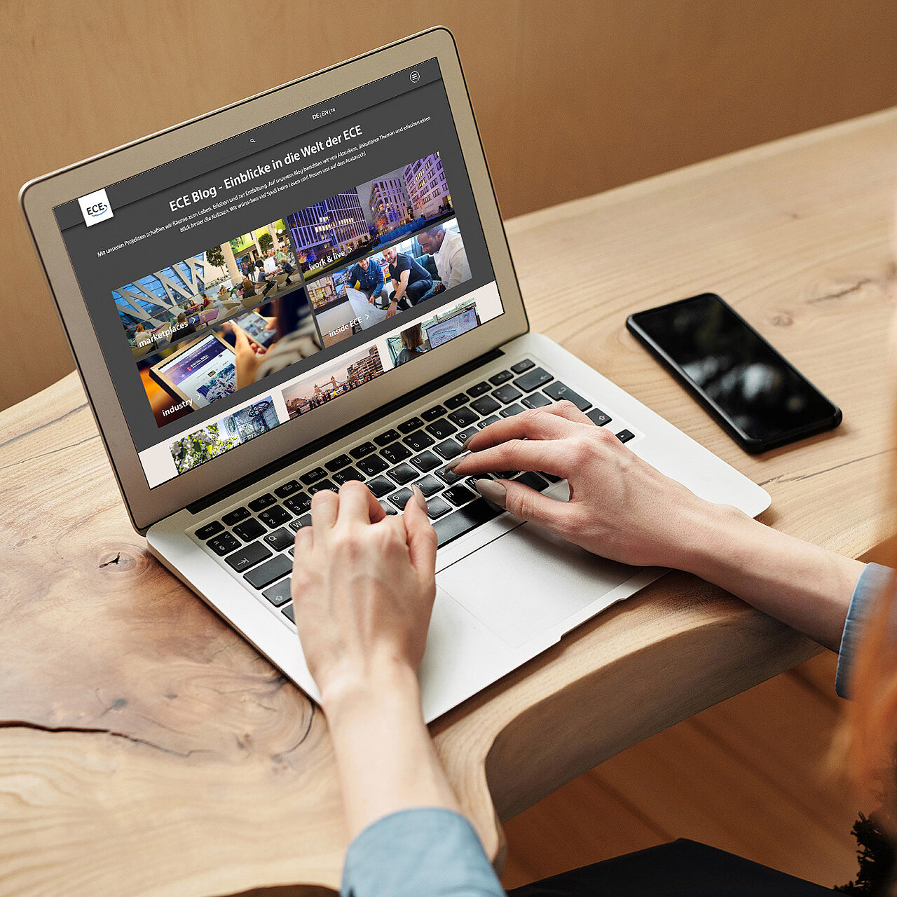 Eine Person scrollt am Laptop durch die Startseite des ECE Blogs.