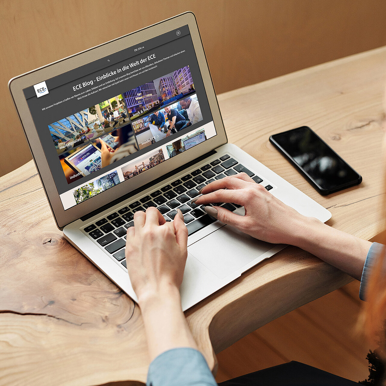 A person scrolls through the home page of the ECE blog on a laptop.