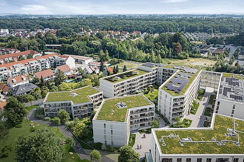 Blick von oben auf ein modernes Wohnquartier mit vielen Grünflächen.