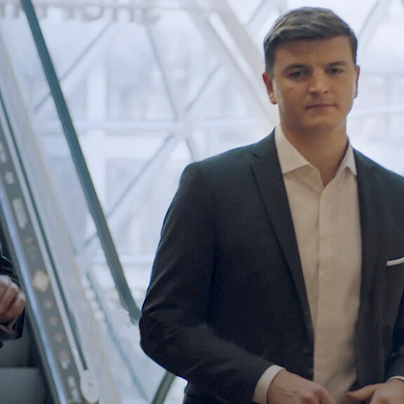 Drei Personen in Geschäftskleidung tauschen sich miteinander aus