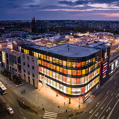 Exterior view of the illuminated Galeria Kaskada shopping center in Szczecin, Poland