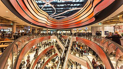 Inside a shopping center with impressive red ceiling lighting and lots of visitors in the aisles