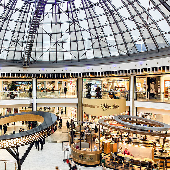 A shopping center from the inside with a large glass dome