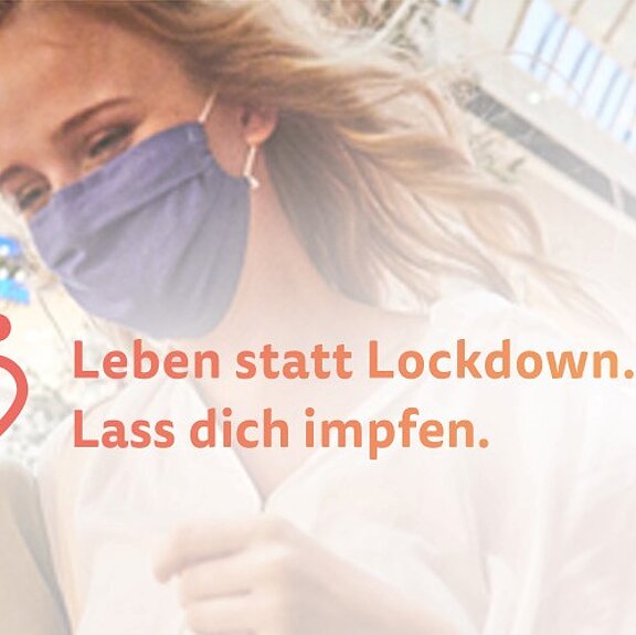 Zwei Frauen befinden sich in einem Shopping-Center und tragen eine OP-Maske