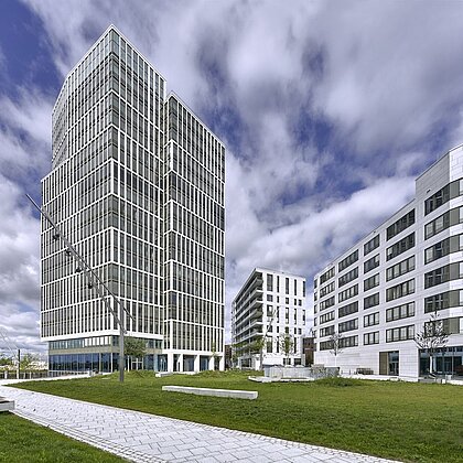 Modern mimariye sahip yüksek katlı bir binanın görünümü.