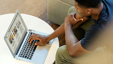 A person is sitting in front of a laptop.