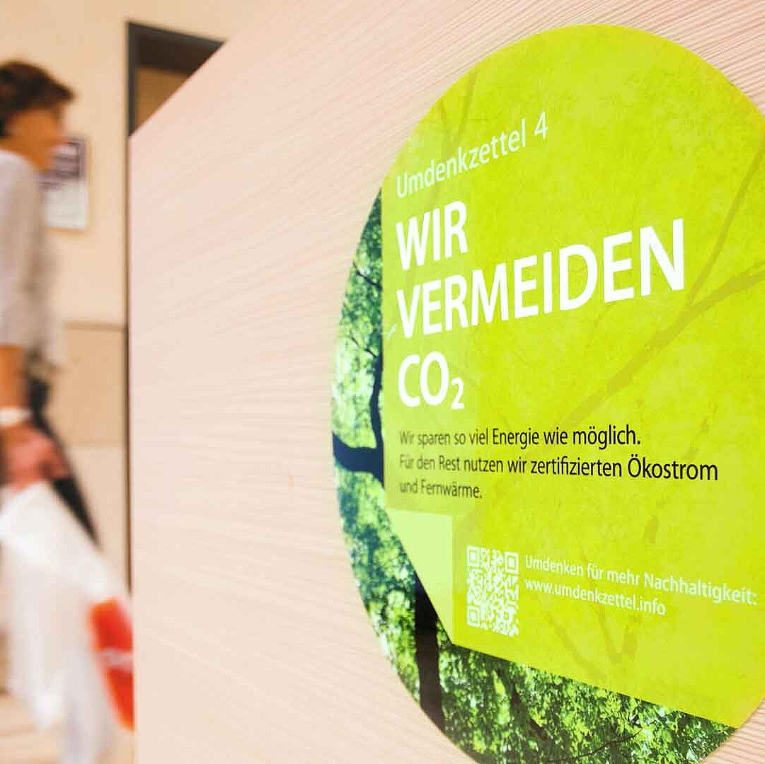 A green sticker with the inscription &quot;We avoid CO2&quot; displayed in a shopping center
