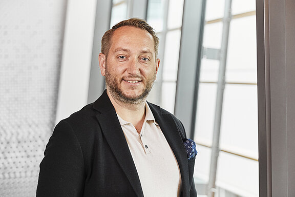 Portrait of Szymon Skwierczynski, smiling friendly into the camera.