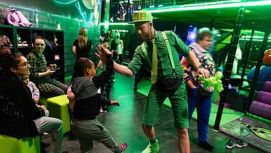 Es sind Menschen im FlipOut zu sehen, ein Kind gibt einem Erwachsenen einen High-Five.